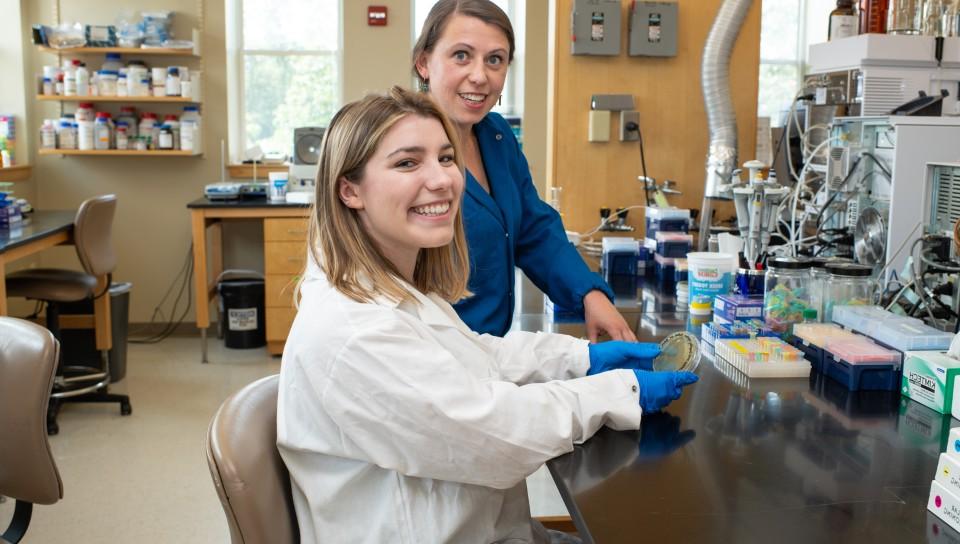伊娃·巴洛格和一名学生在新的波特兰生物技术和健康科学实验室做研究时摆姿势拍照